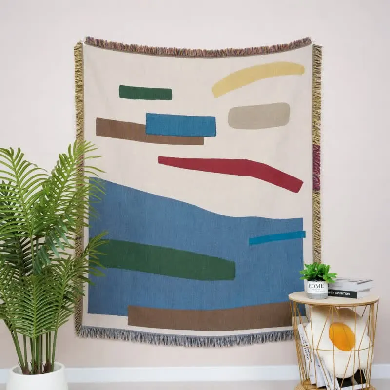 Künstlerisch gestaltete, geometrische, mit Fransen und Quasten verzierte Tagesdecke