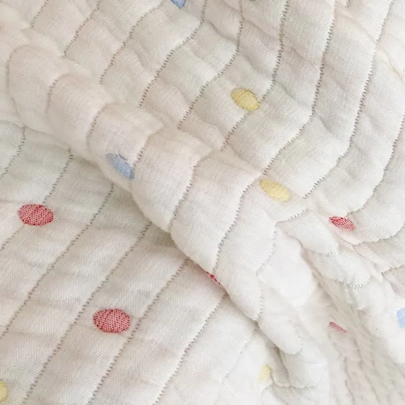 Cremefarbene, leichte Steppdecke aus gewaschenem Lyocell mit Konfetti-Punkten.