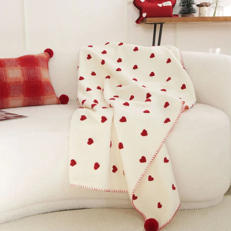 Herzförmige Kuscheldecke mit Pompons