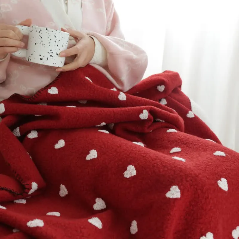 Herzförmige Kuscheldecke mit Pompons