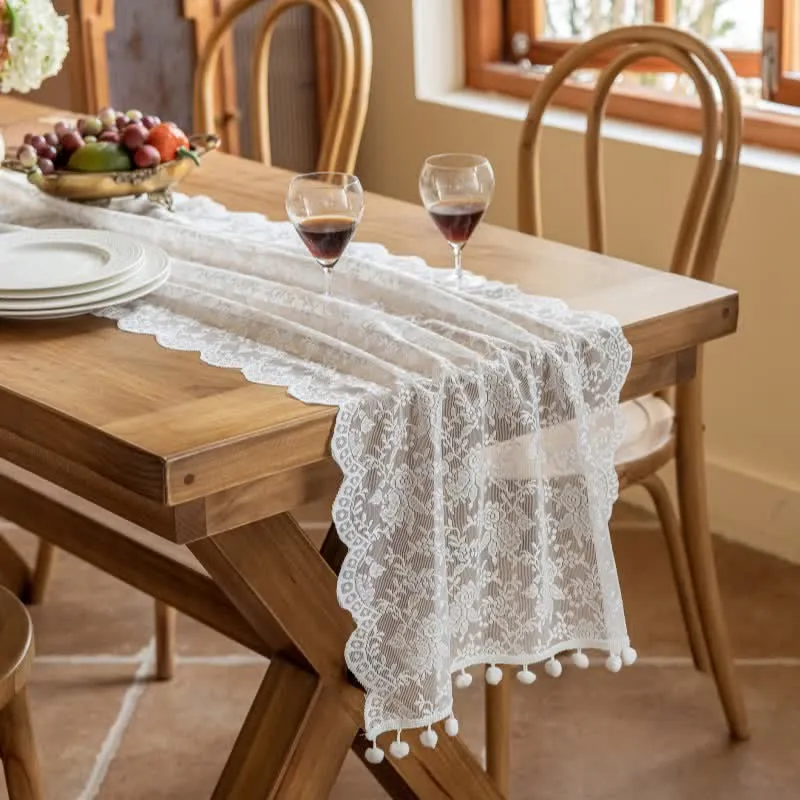 Eleganter Tischläufer mit floraler Spitze und Quasten