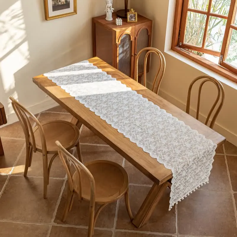 Eleganter Tischläufer mit floraler Spitze und Quasten