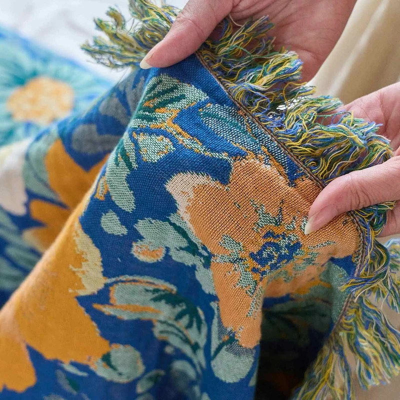 Patchworkdecke aus Baumwollgaze mit hellem Gänseblümchenmuster und Quasten