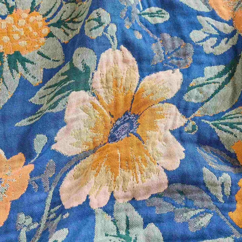 Patchworkdecke aus Baumwollgaze mit hellem Gänseblümchenmuster und Quasten