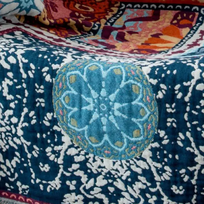 Boho-Steppdecke aus Baumwolle mit Wendequasten und blauen Blumen