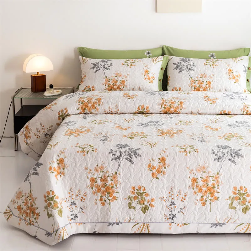 Orangefarbene Baumwollsteppdecke mit floralem Botanikdruck
