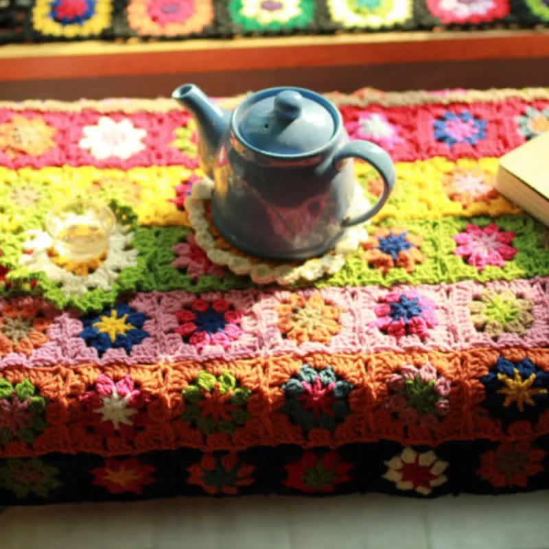 Handgewebte, funktionelle Häkeldecke mit leuchtenden Gänseblümchen